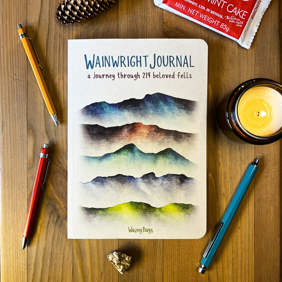 Wainwright Journal by Wainy Days on a desktop with pencils and a candle