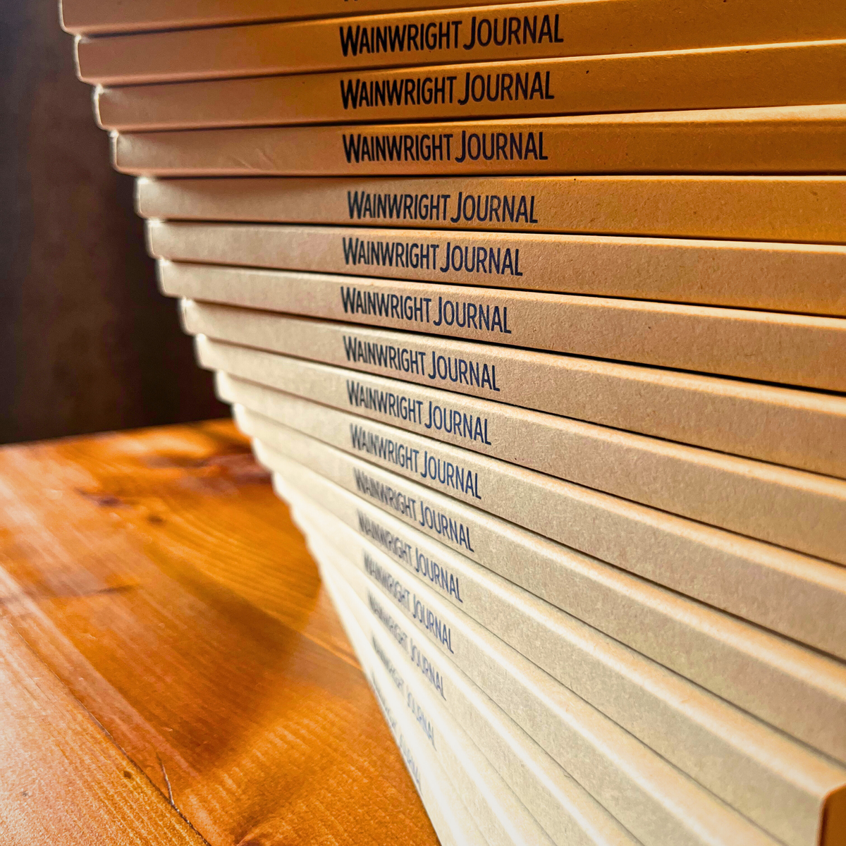 Stack of Wainwright Journal books on a wooden surface