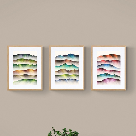 Three framed pieces of abstract wall art on a beige wall.