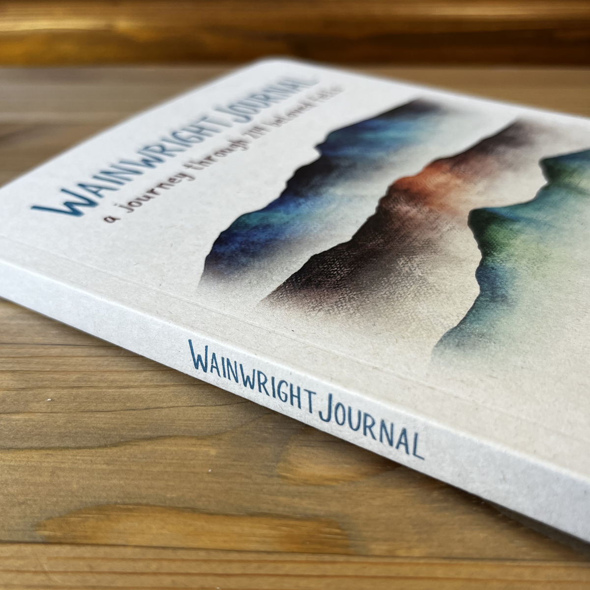 Book titled 'Wainwright Journal' on a wooden surface